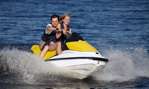 Happy smiling caucasian couple riding jet skiHappy smiling caucasian couple riding jet ski